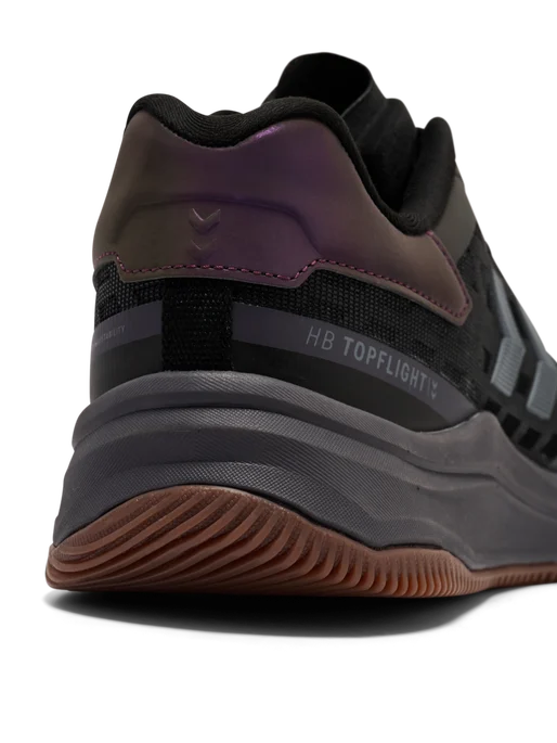 Hummel HB Topflight håndboldsko i sort med lilla skinnende detalje og brun gummisål, nærbillede af hælpartiet set skråt bagfra