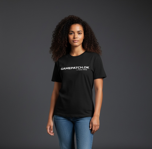 Kvindelig model med krøllet hår i sort GAMEPATCH.DK t-shirt og jeans mod mørkegrå studiebaggrund